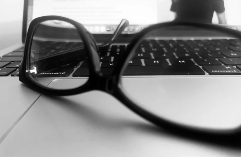 Gafas sobre el teclado de un portátil, en blanco y negro